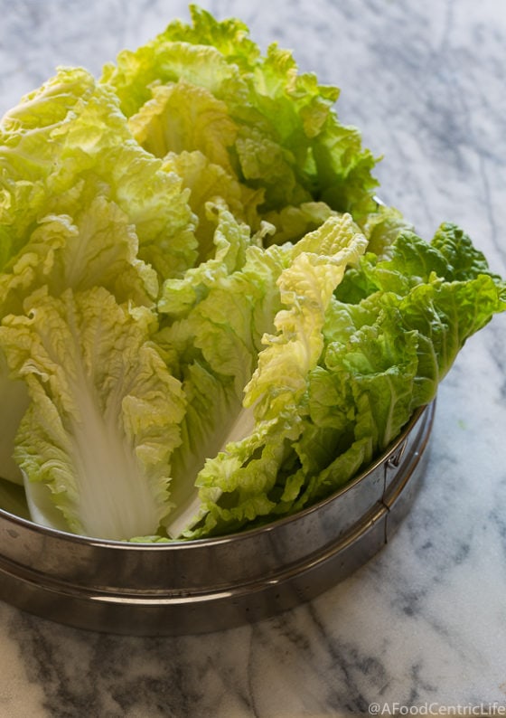 Ruffles Napa Cabbage leaves on a marble counter.