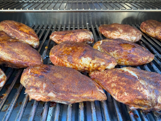 Grilled chicken breasts done with dry rub still on the grill.