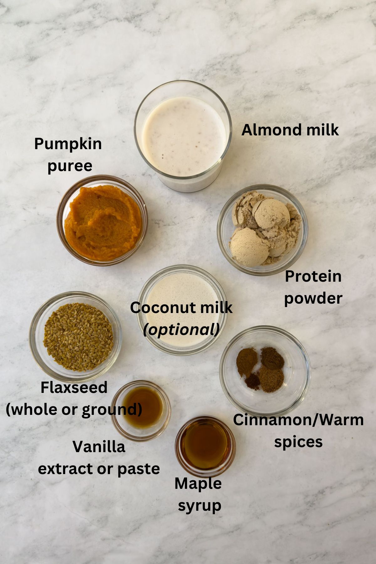 Ingredients for a pumpkin smoothie on a marble counter. 