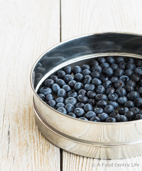 fresh dark blueberries in a sieve.
