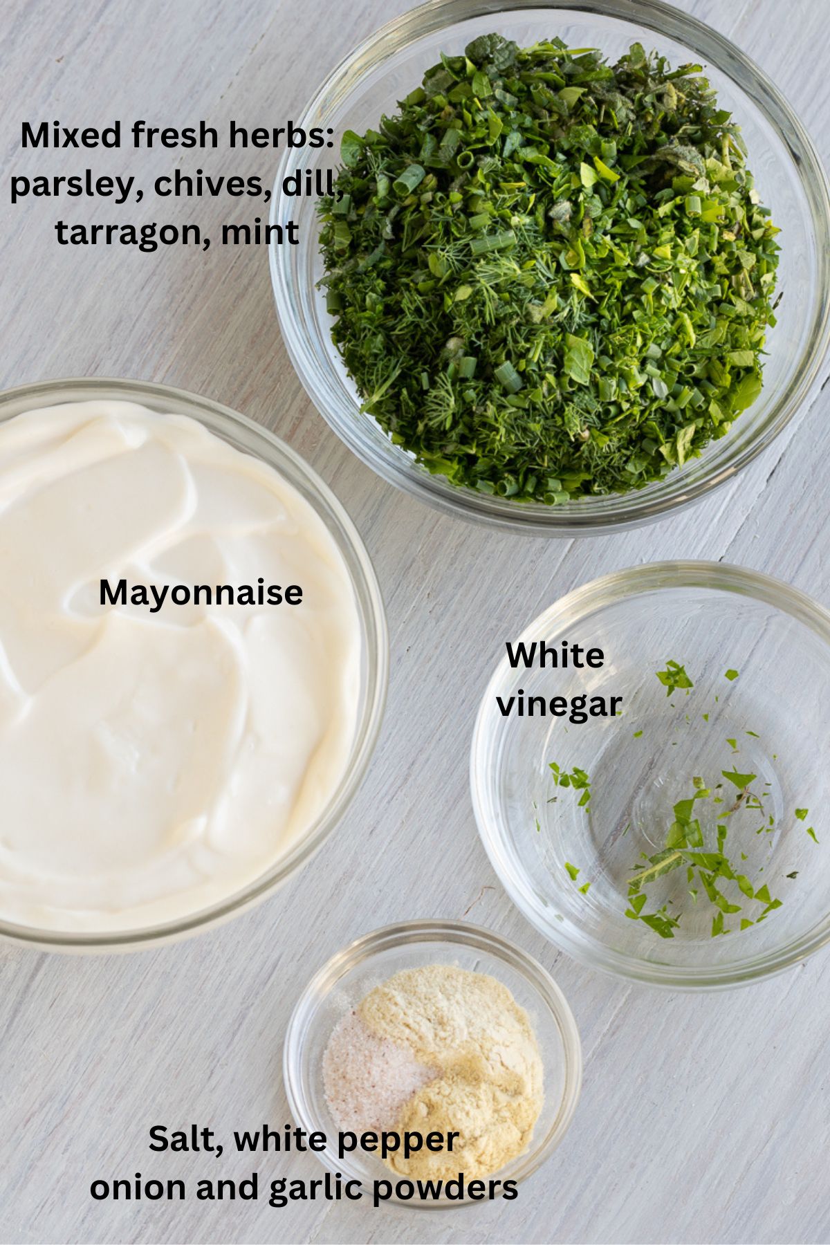 Ingredients for green goddess dressing and dip with lots of fresh green herbs.