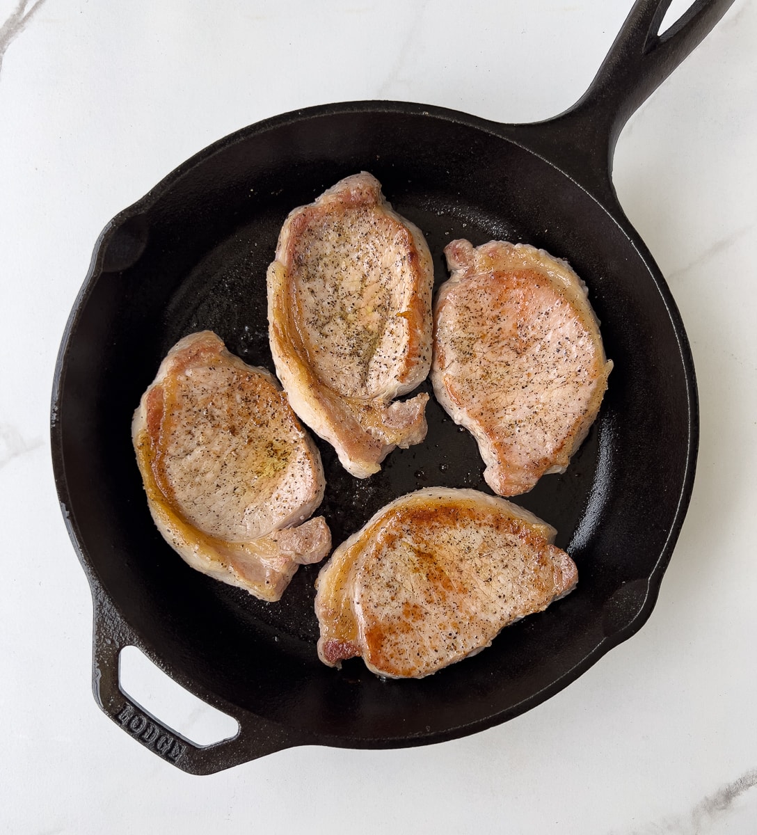 Browned pork chops in cast iron.