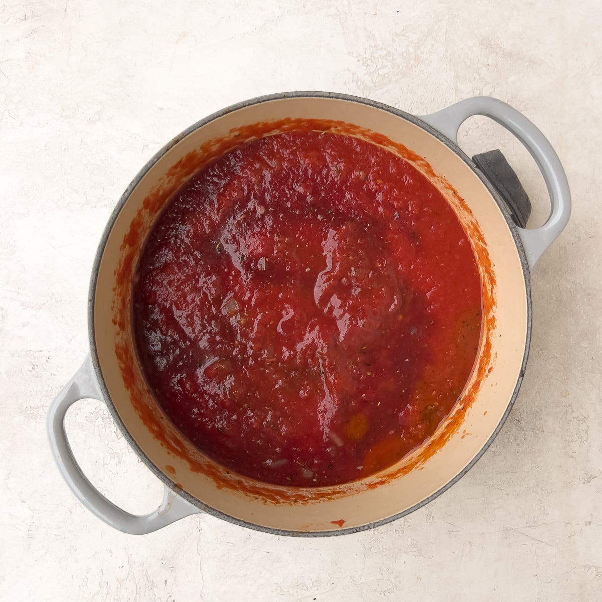 Tomato marinara simmering with red wine in a pot. 