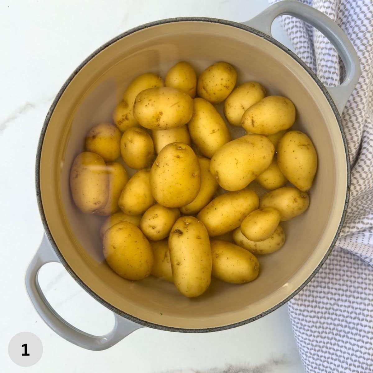 Cooking baby dutch potatoes in a gray pot.