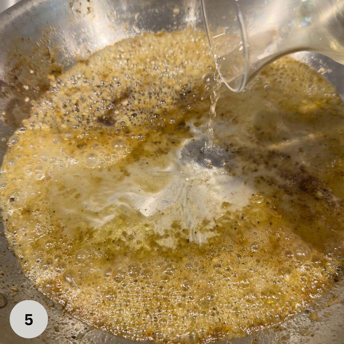 Deglazing a pan to make a pan sauce with mustard cream.