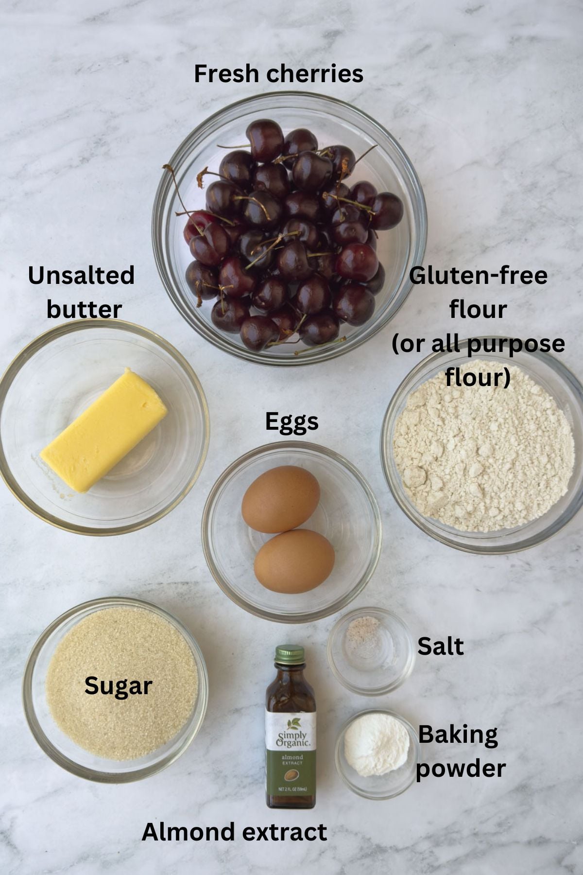 Ingredients for a cherry clafoutis in prep bowls on a kitchen counter.