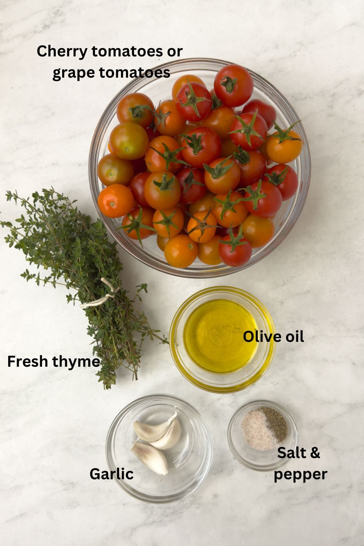 Ingredients for roasted cherry tomatoes on the counter in glass bowls.
