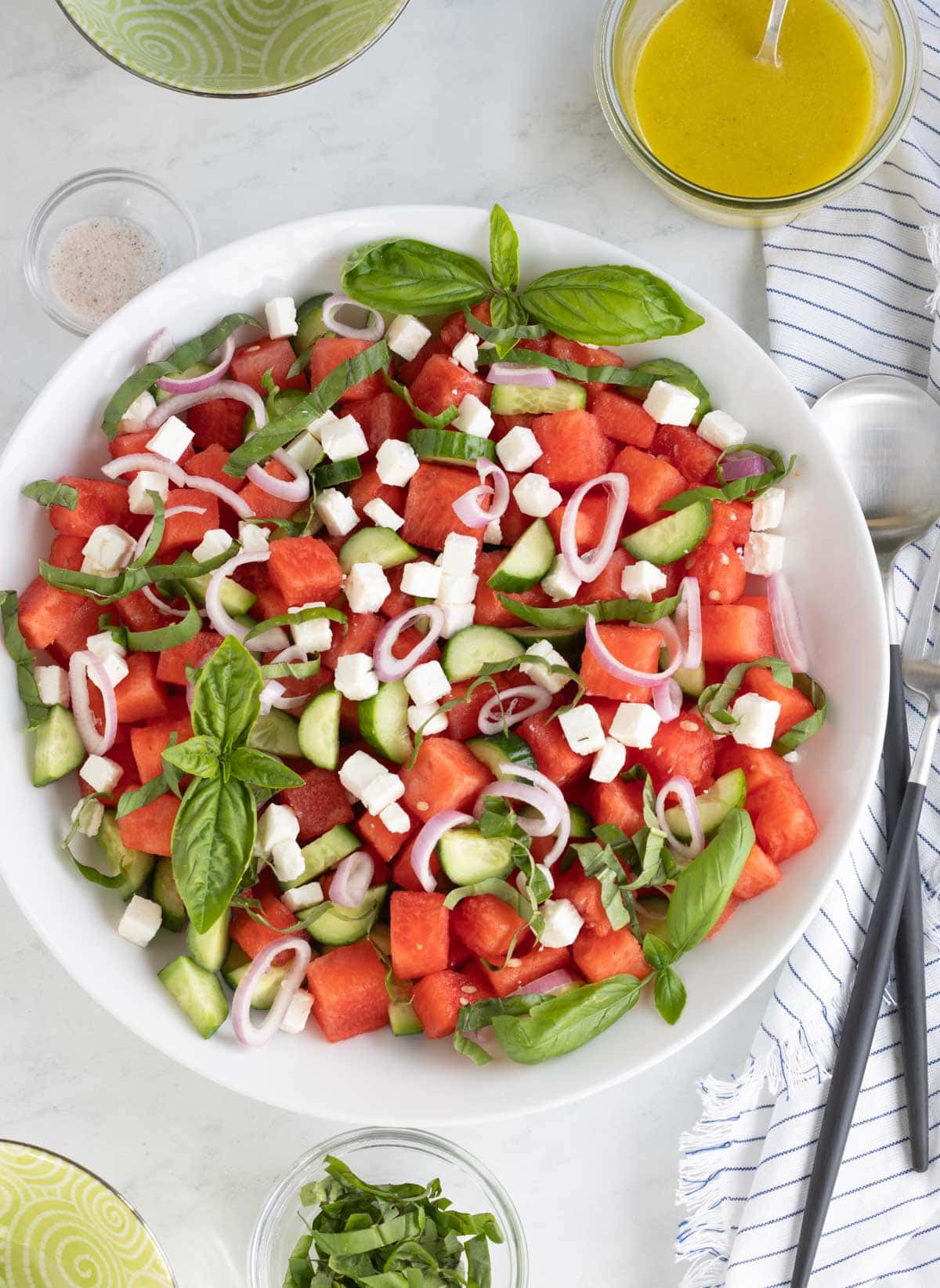 Colorful watermelon salad with feta, shallots, basil, and cucumber.