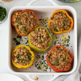 Colorful baked ground turkey stuffed peppers with quinoa and herbs.