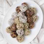 A small plate of peanut butter protein balls, plain, and rolled in hemp seeds and coconut.
