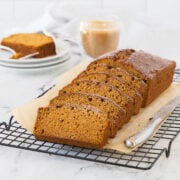 A golden loaf of pumpkin bread sliced and ready to enjoy with coffee.