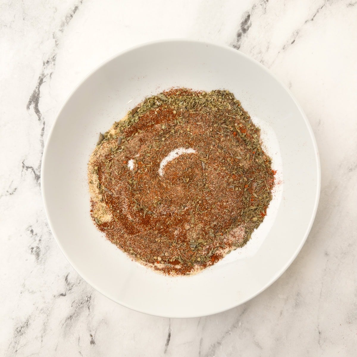 A plate of mixed spices making up Cajun blackening seasoning blend.