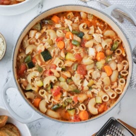 A large pot of colorful chicken minestrone with toasts and parmesan. soup