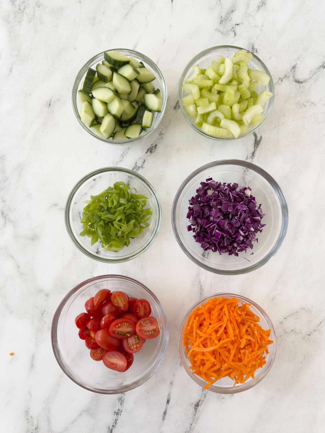 Prepped ingredients for a buffalo chicken salad in small bowls.