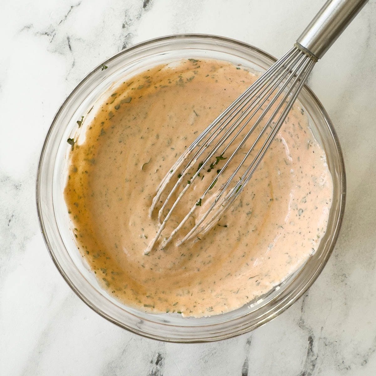 Finished buffalo ranch dip in a bowl with a whisk.