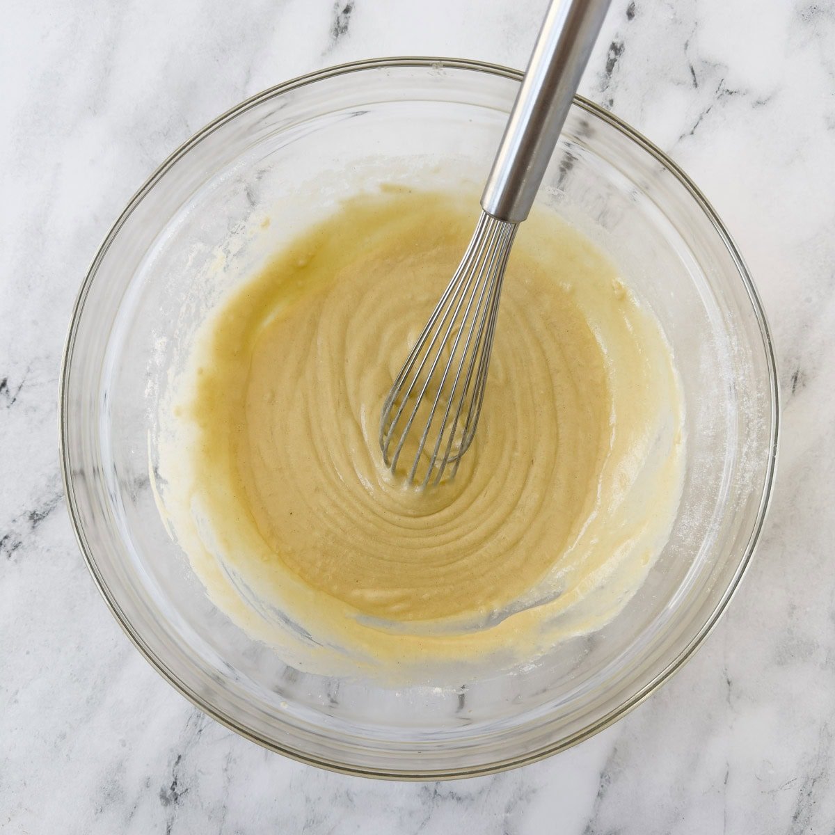 Smooth whisked batter to pour over a peach cobbler.