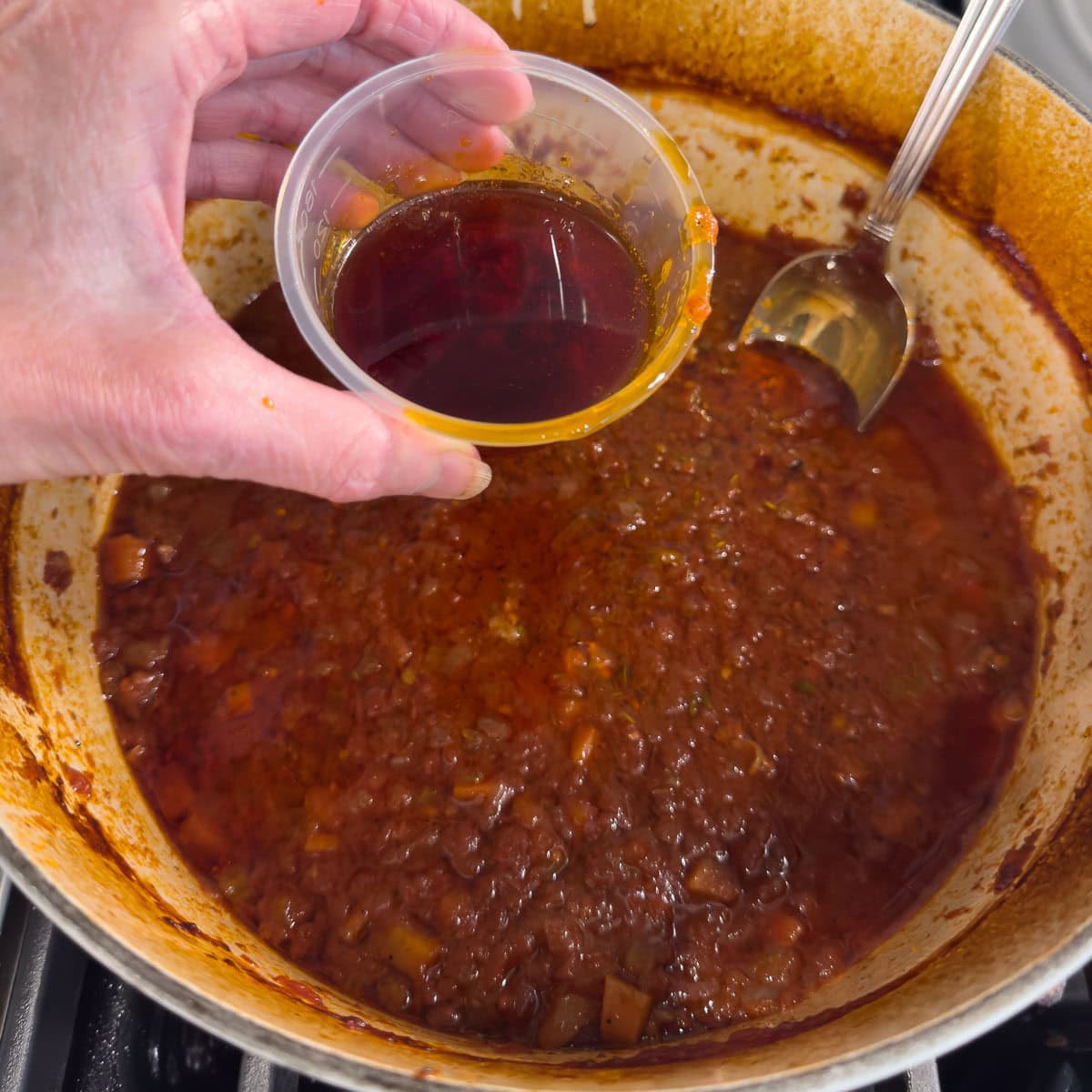 Degreasing a pot of braised beef ribs.