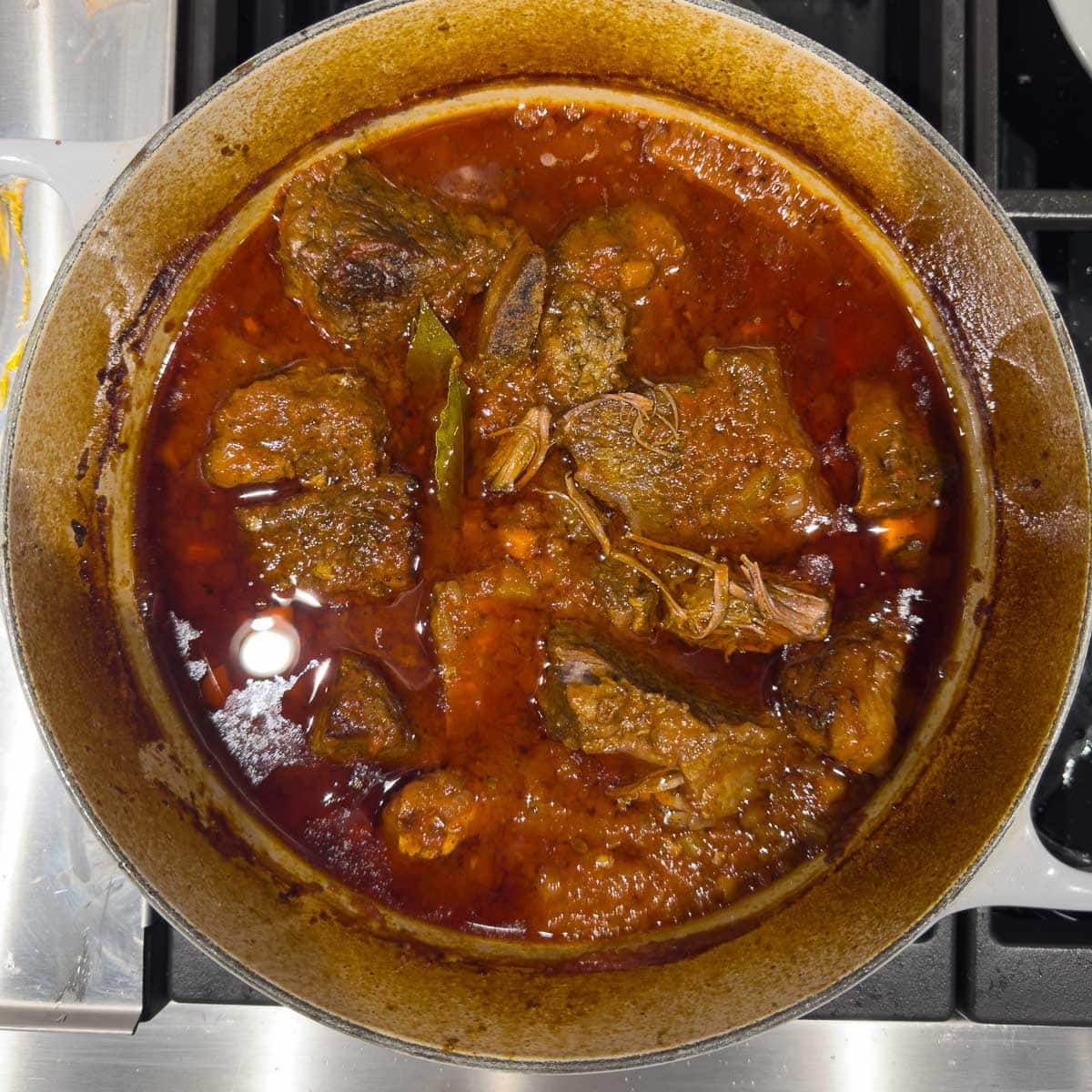 A pot of beef short ribs finished braising in wine and broth.