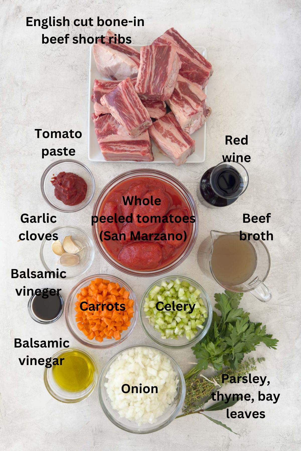 Ingredients for beef short rib ragu in prep bowls on the counter.