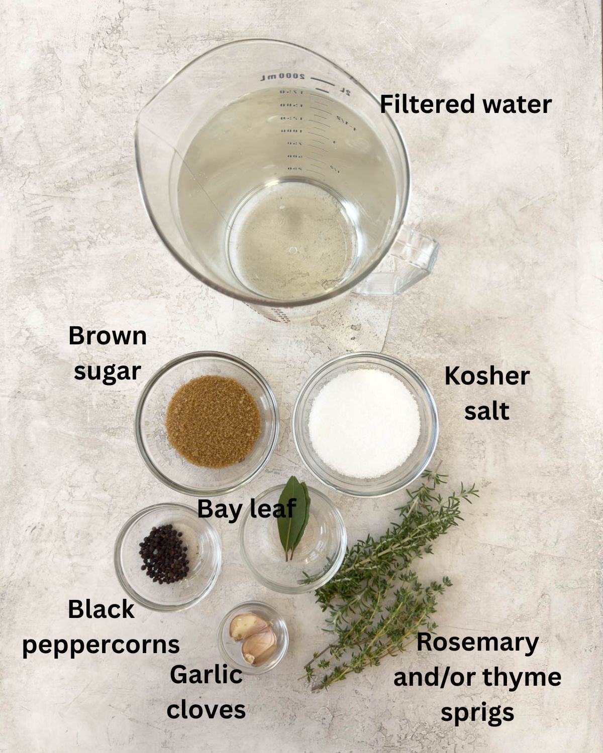 Ingredients for pork brine in glass prep bowls on the counter.