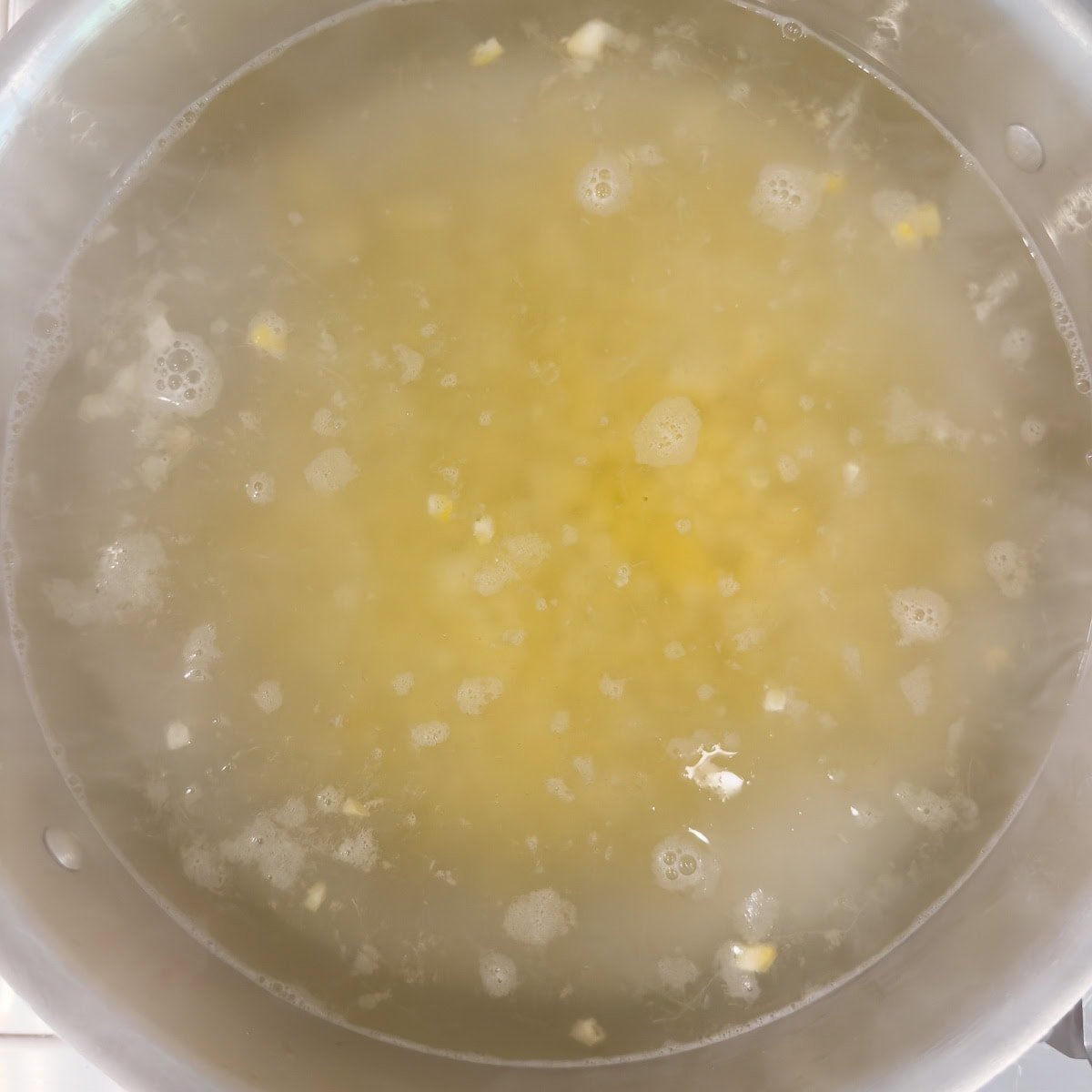 Cooking corn kernels in a pot of water.