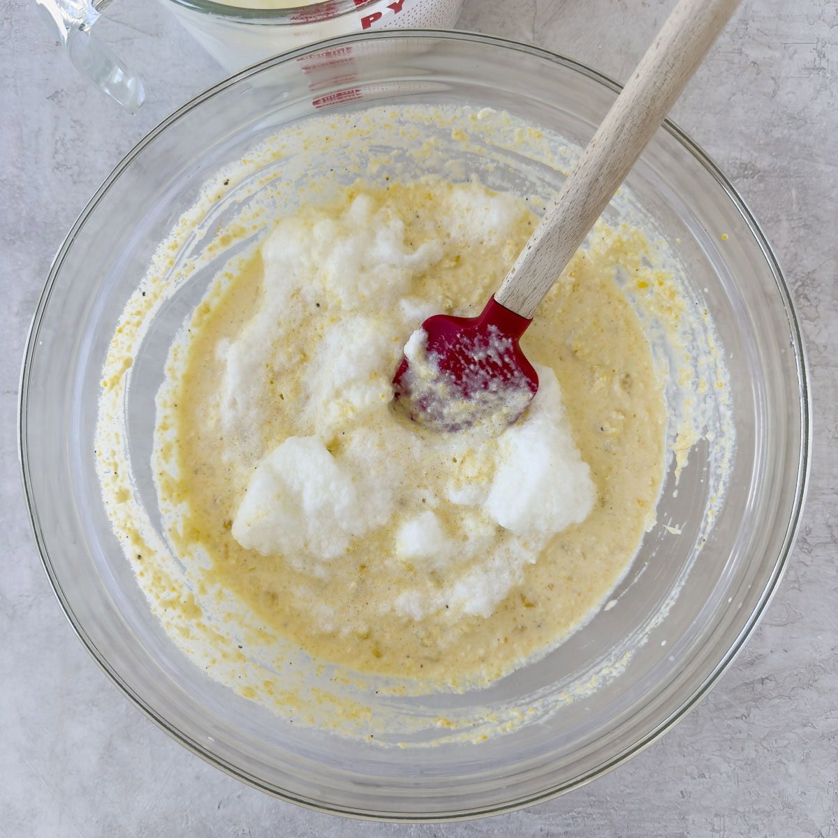 Folding egg whites into the corn souffle batter. 