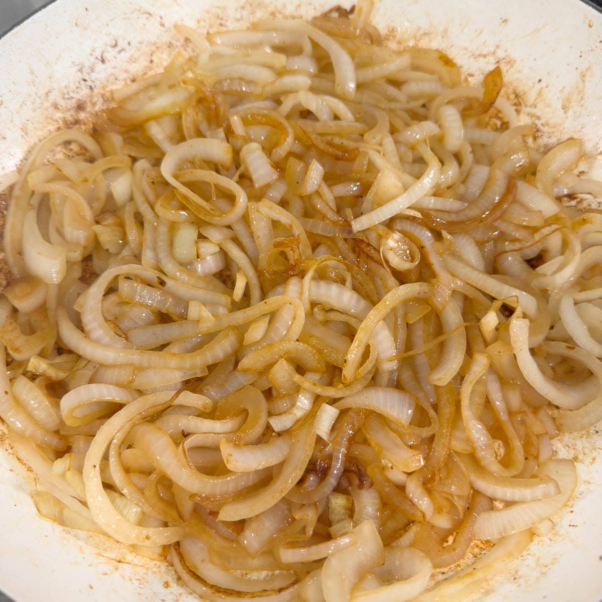 Light golden caramelized onions in a round shallow pan.