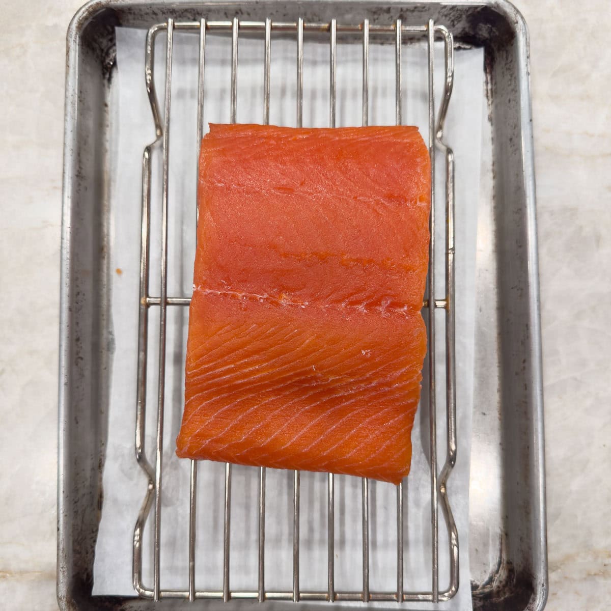 Salmon filet rinsed after curing to dry for smoking.