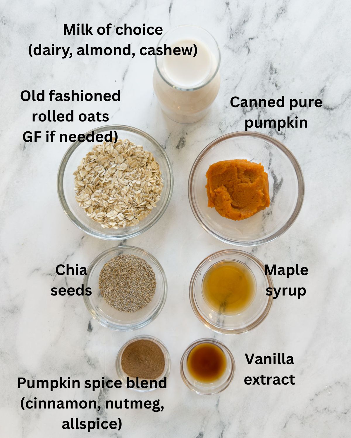 Ingredients for pumpkin overnight oats on a marble counter.