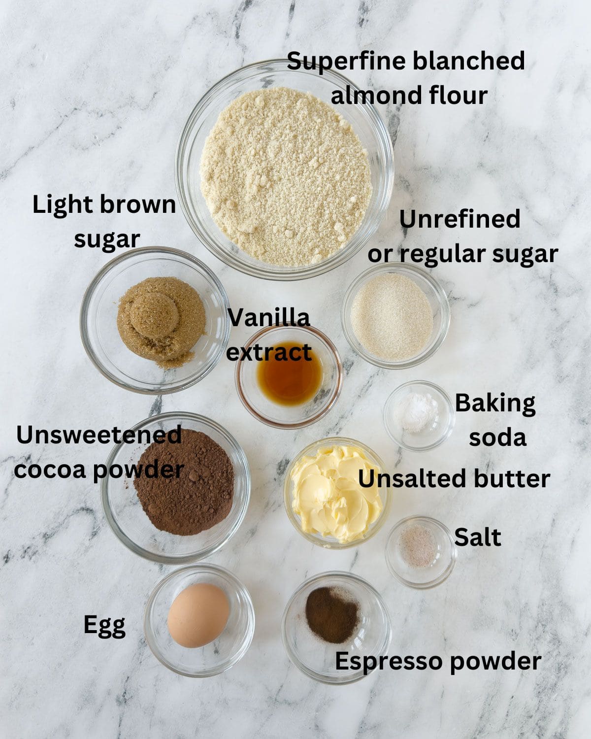 Almond flour, cocoa powder, sugar, and other ingredients for chocolate almond flour cookies.