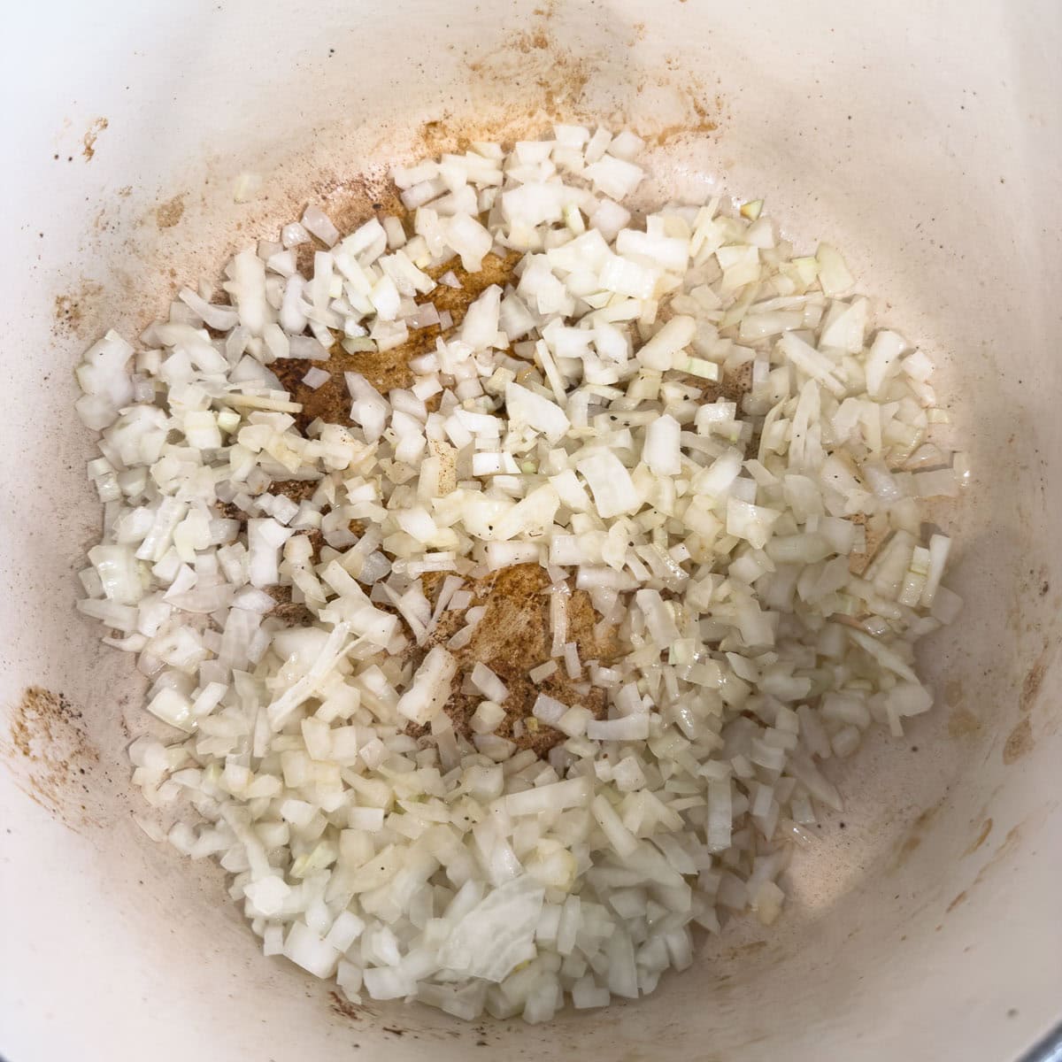 Chopped onion saut&eacute;ing in a pot in olive oil.