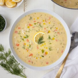 A bowl of Greek avgolemono chicken soup with fresh dill in a white bowl.