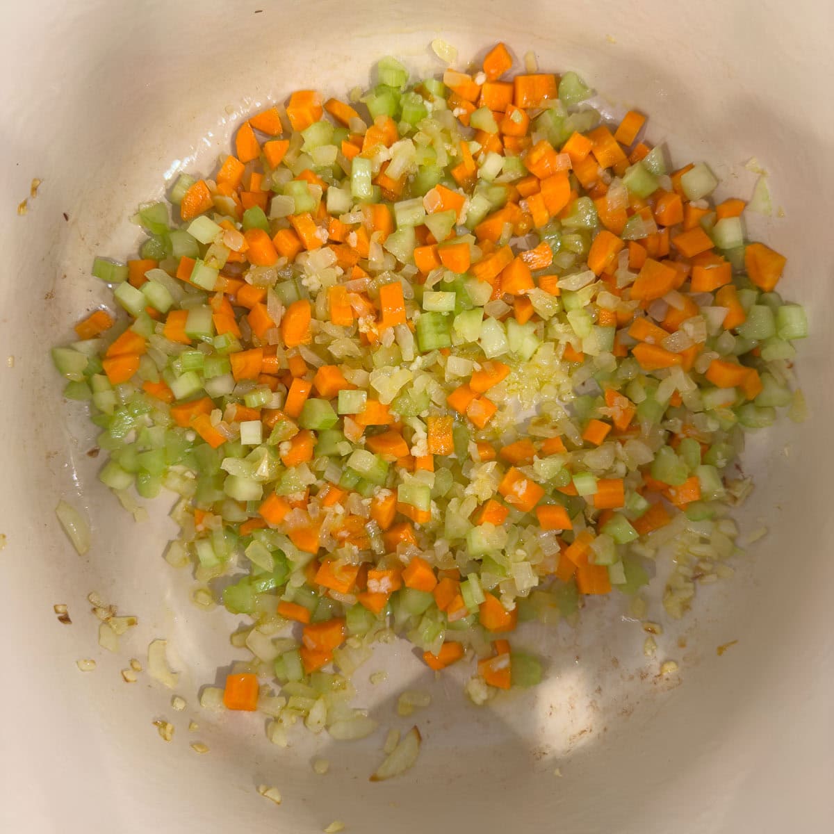 Onion, carrots, celery , and garlic cooking in a large pot.