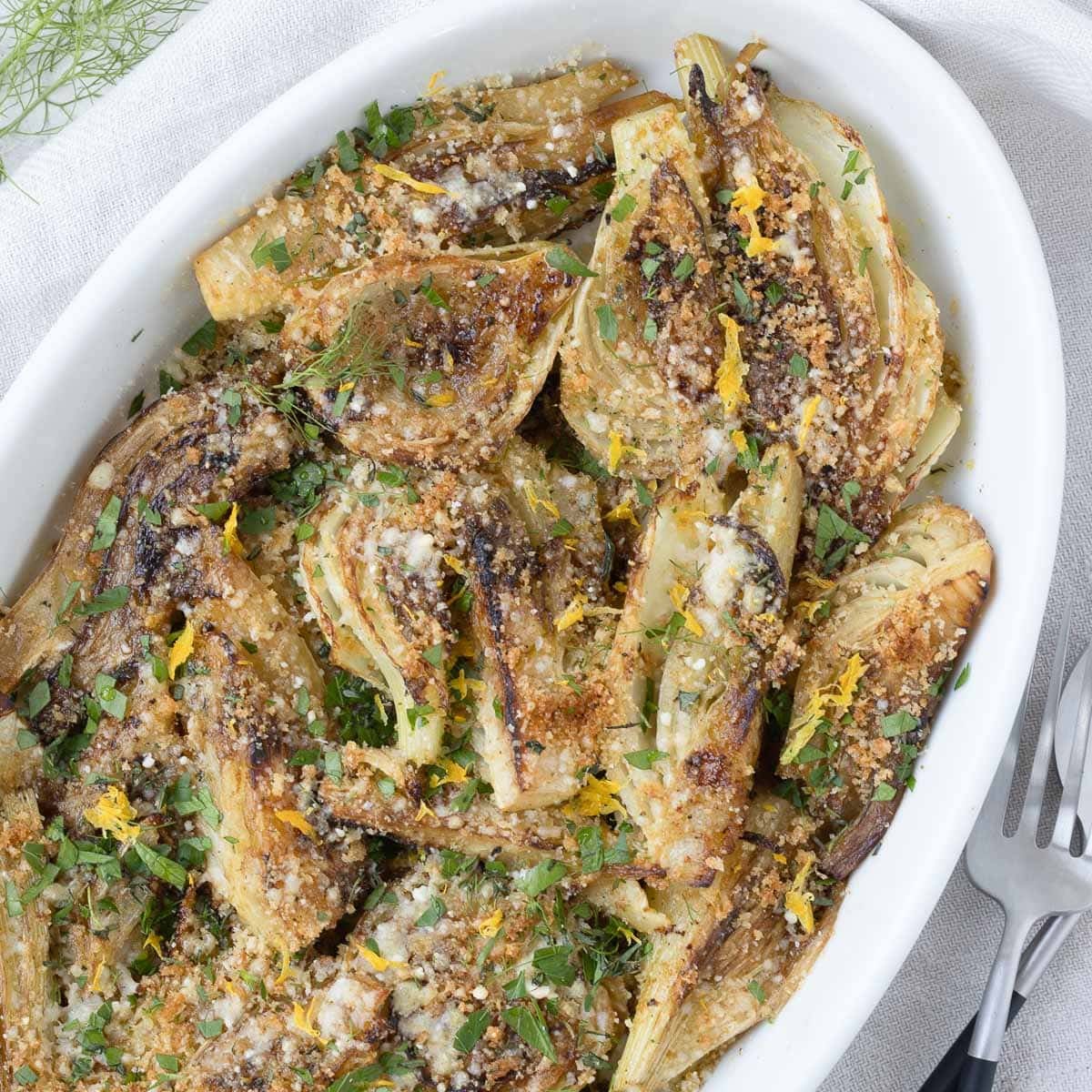 An oval baking dish with braised fennel and a crunchy topping or parmesan and toasted
breadcrumbs.