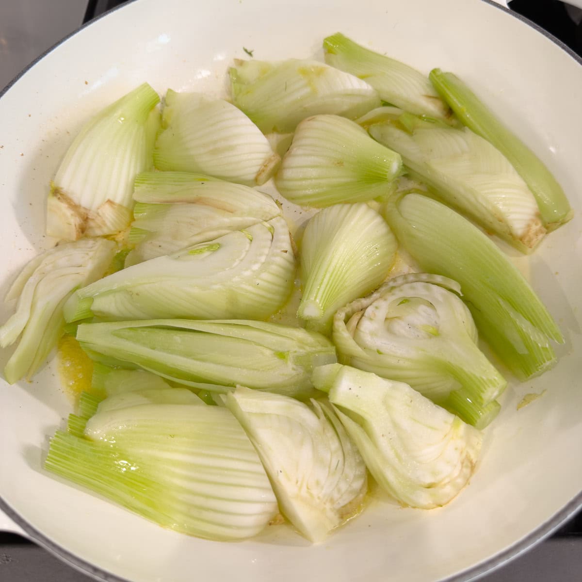 Searing fennel wedges in a pan with butter and olive oil.