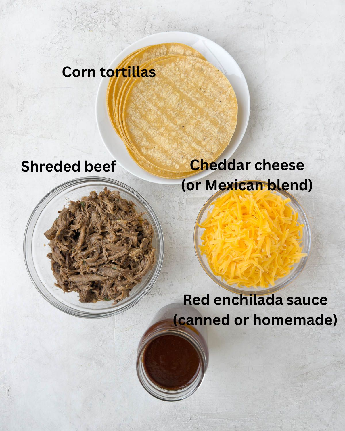 Corn tortillas, red enchilada sauce, grated cheddar cheese, and shredded beef to make enchiladas.