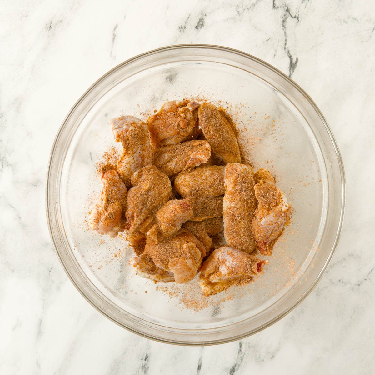 Chicken wing flats and drumettes seasoned with dry rub before baking.