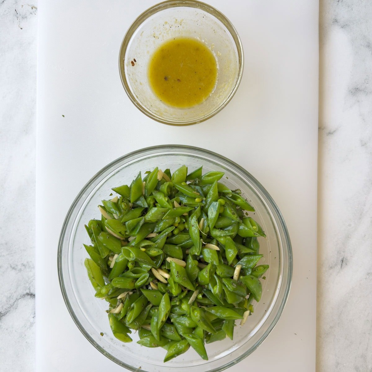 Dressing a fresh snap pea salad with a golden vinaigrette.