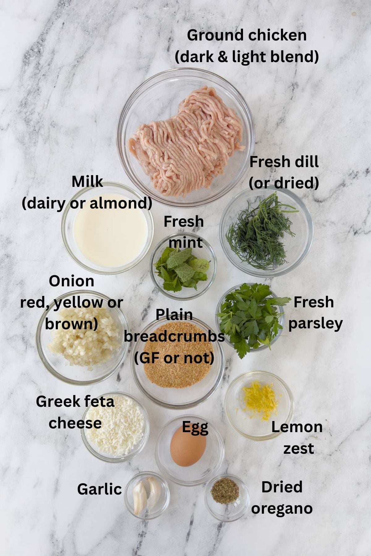 Ingredients for Greek chicken meatballs in prep bowls on the counter.