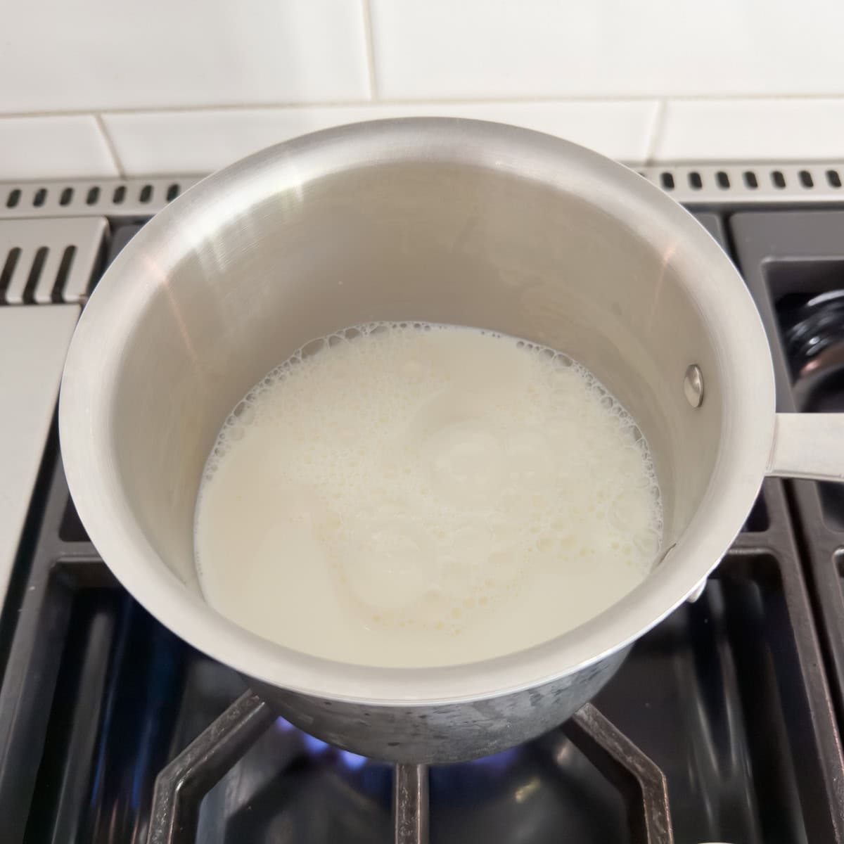 Heating milk in a small saucepan on the stovetop.