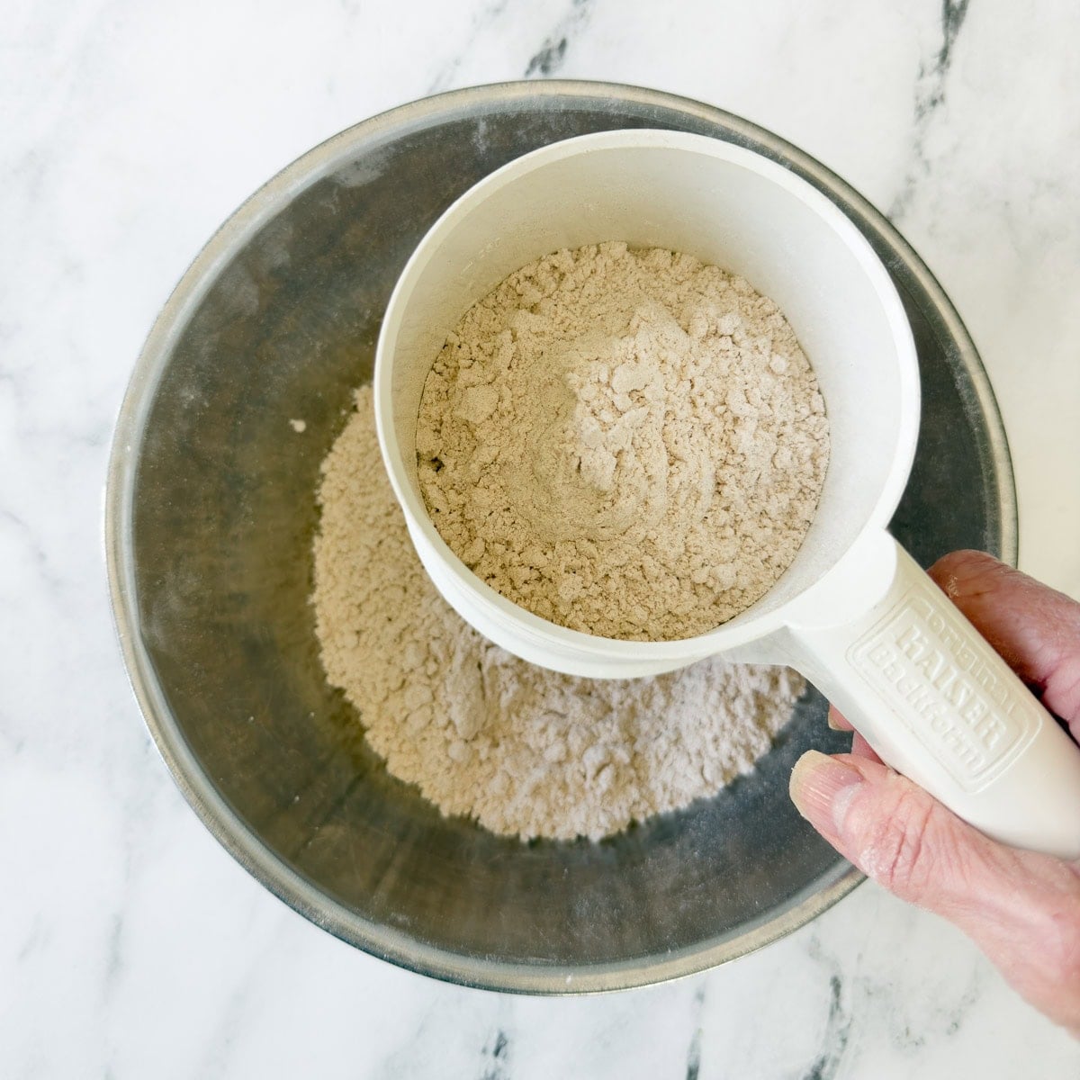 Sifting dry ingredients together for making cinnamon muffins.