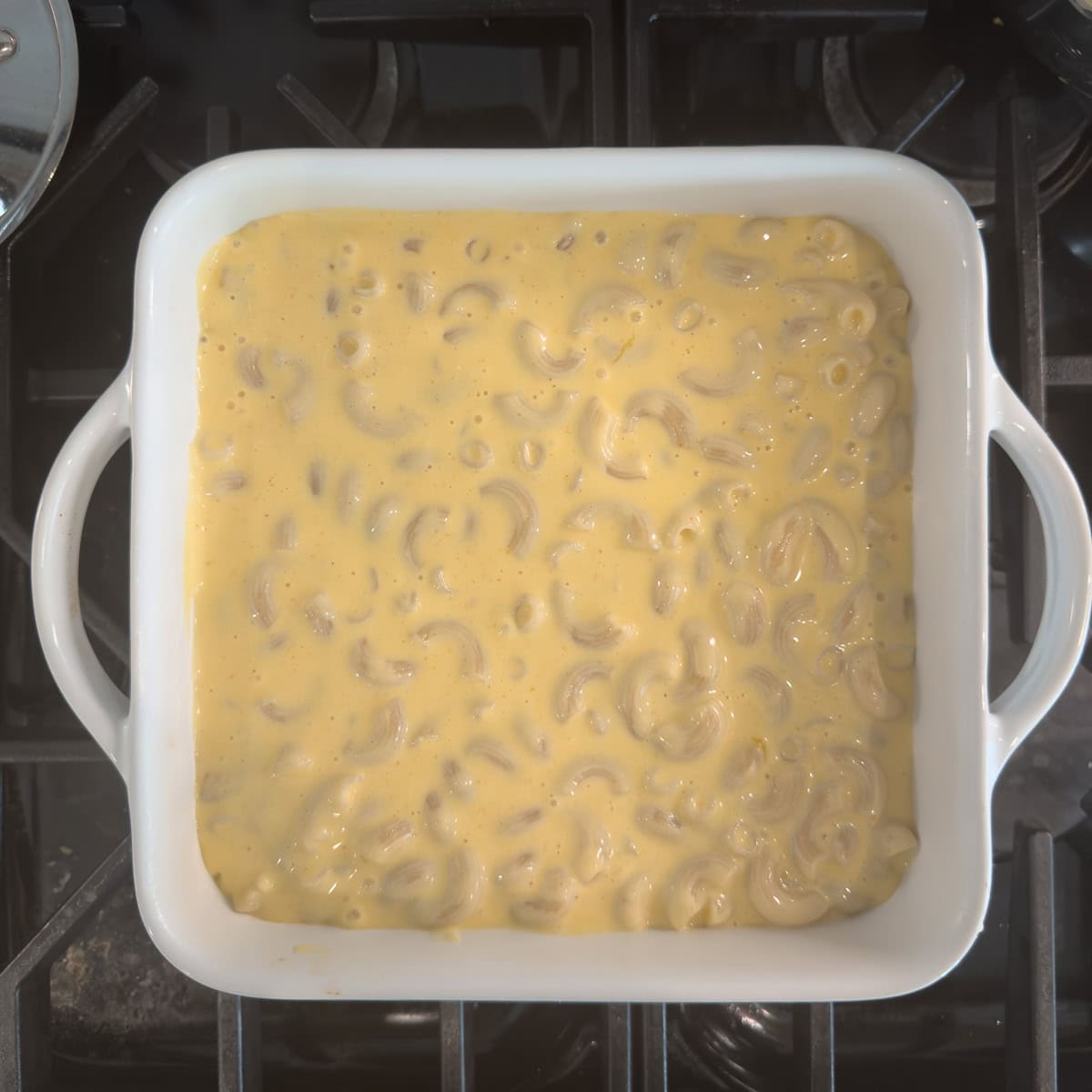 Mac and cheese ready to bake in a square white baker.