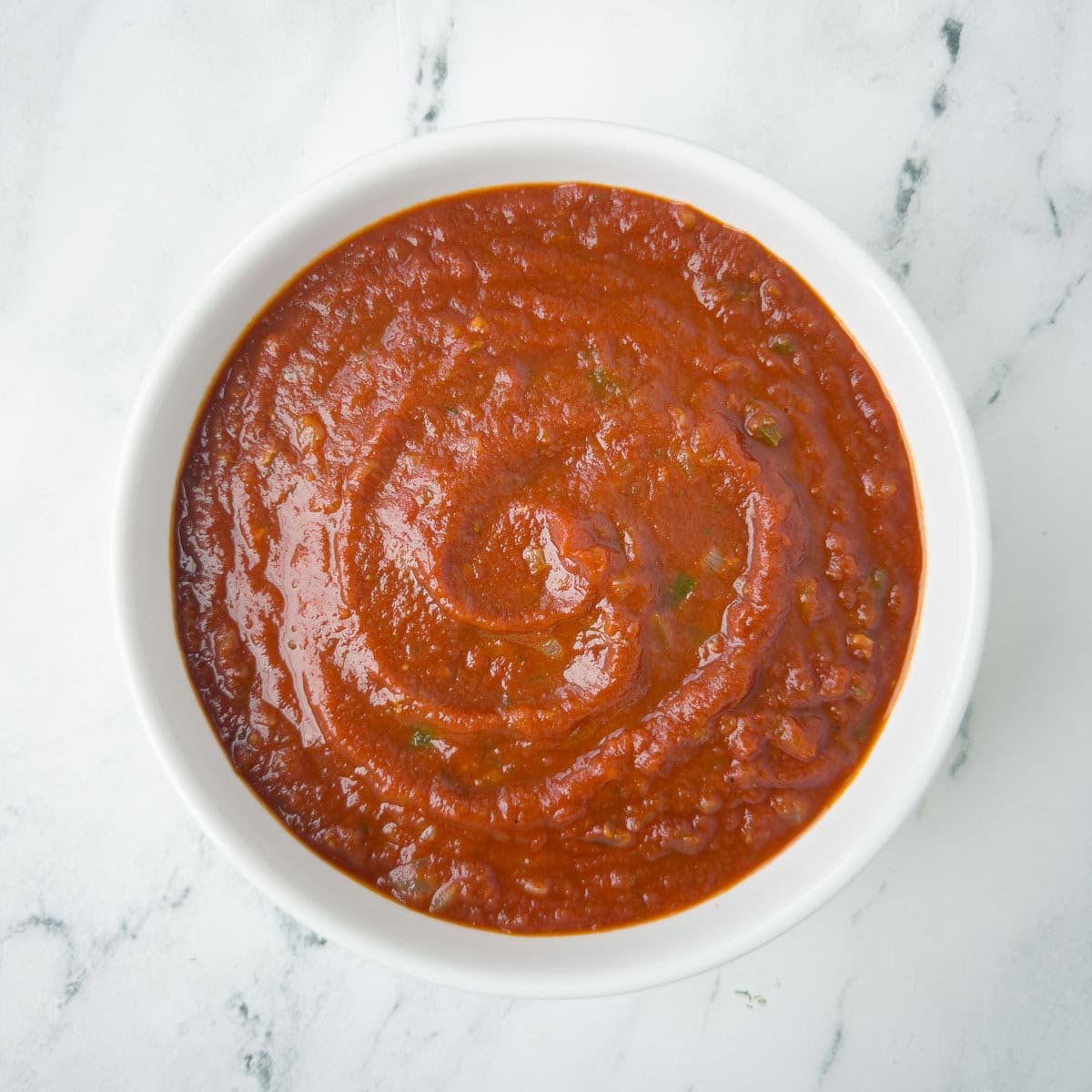 Chunky ranchero sauce in a white bowl.