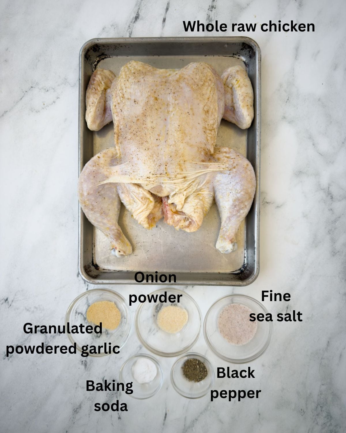 A whole chicken, and spices to roast, ingredients on the counter.
