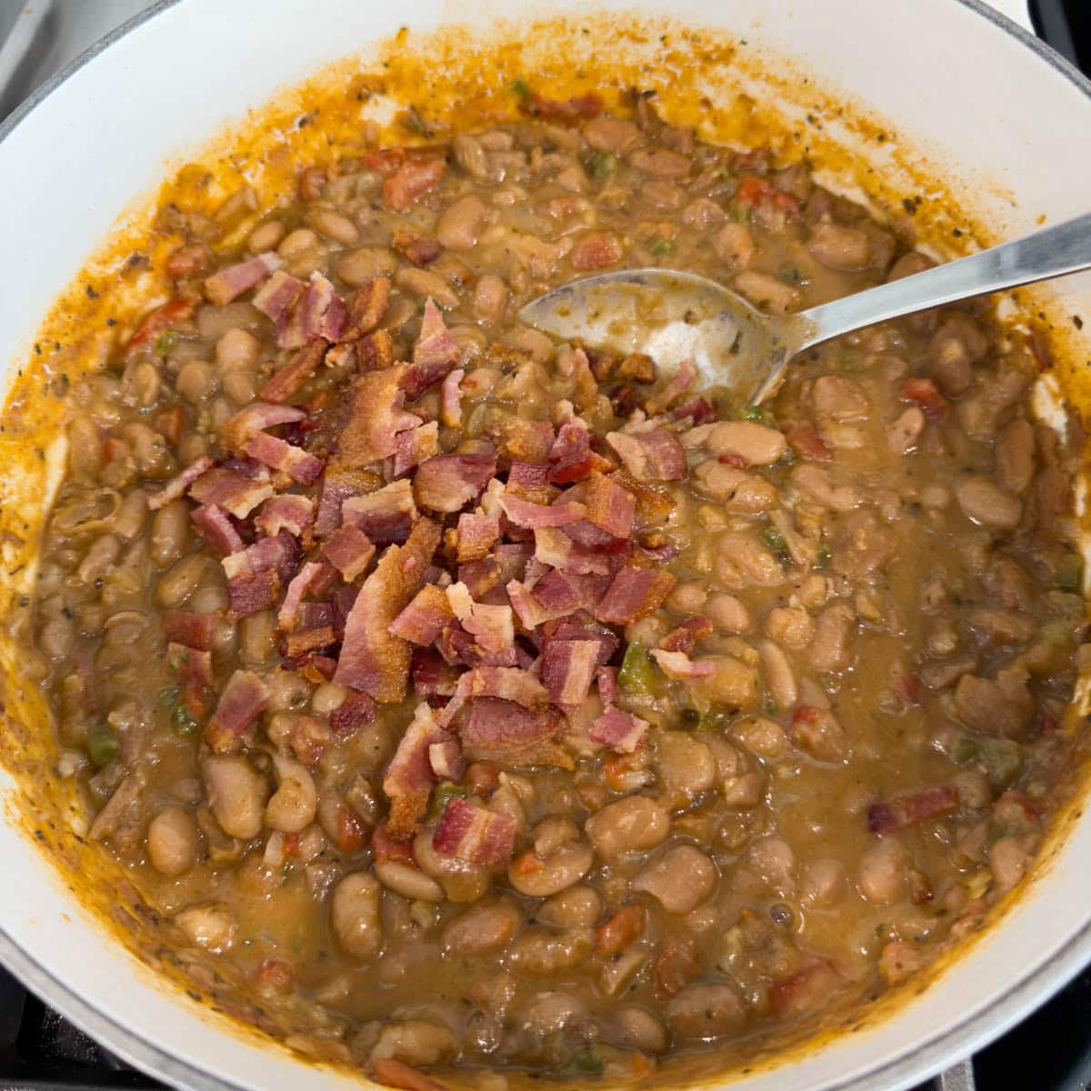 Chopped crisp bacon added to a pot of pinto beans.