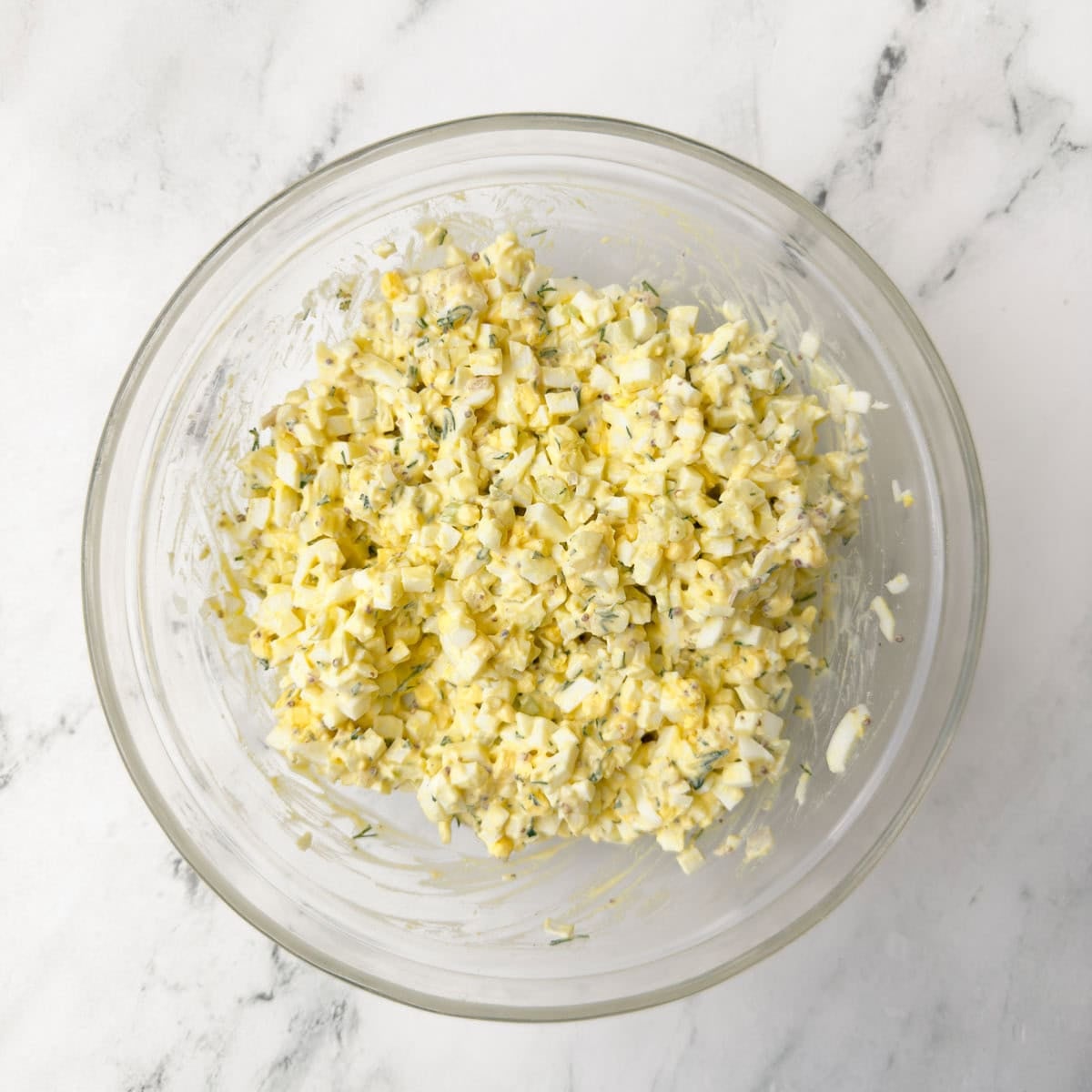 Finished egg salad in a glass bowl ready for serving.