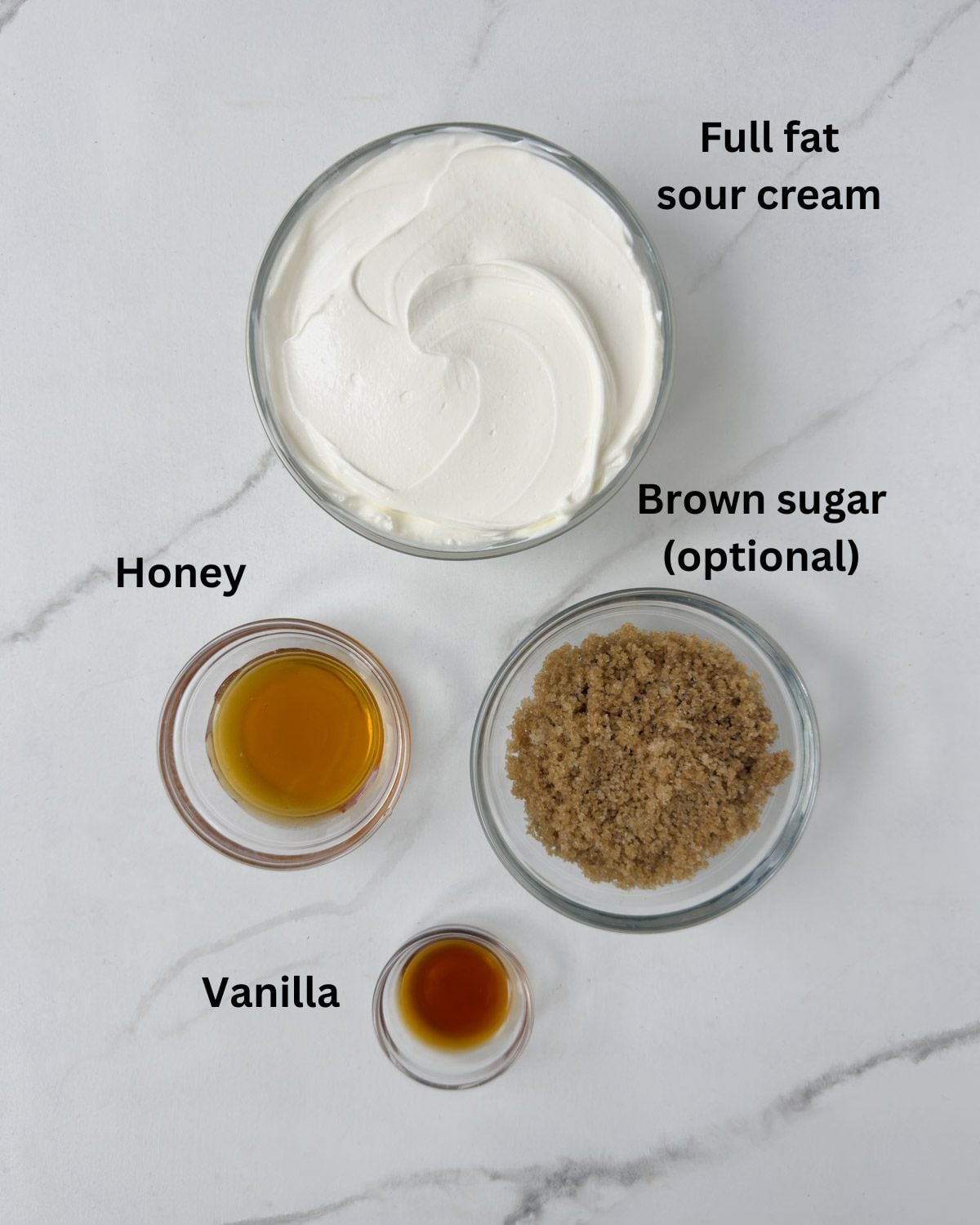 Ingredients in prep bowls for a sour cream, honey, and vanilla fruit dip.