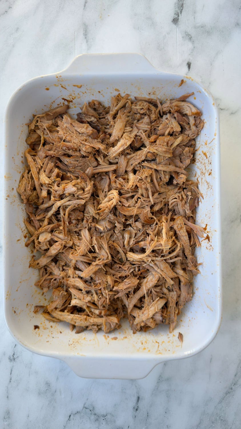Finished slow cooker bbq pulled pork in a casserole dish.