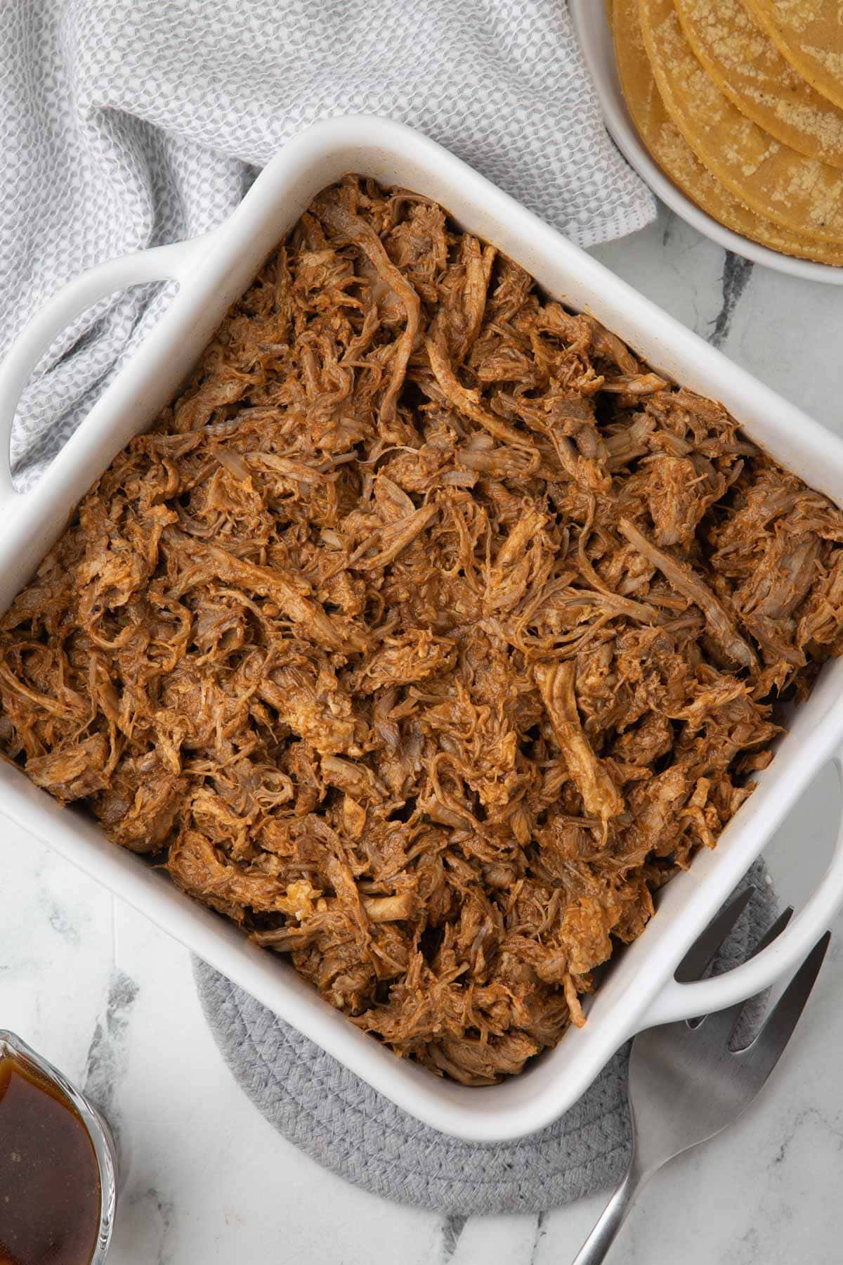 A white square baker filled with rich juicy bbq pulled pork.