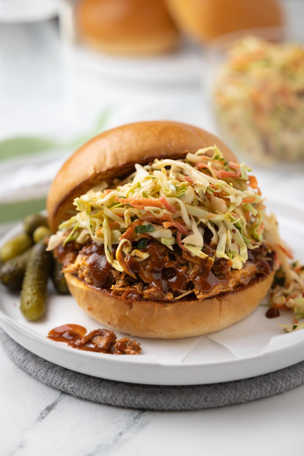 A slow cooker bbq pulled pork sandwich piled with coleslaw on a golden bun.